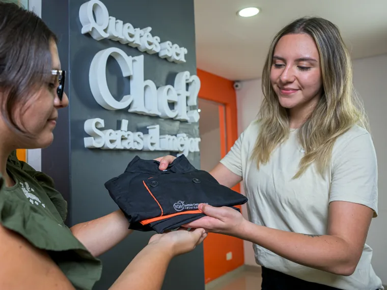 Entrega del uniforme de IGI a una alumna en la recepción de una sede