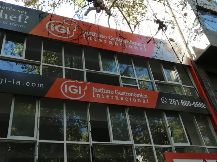Fachada de una sede de IGI con su cartel y su teléfono